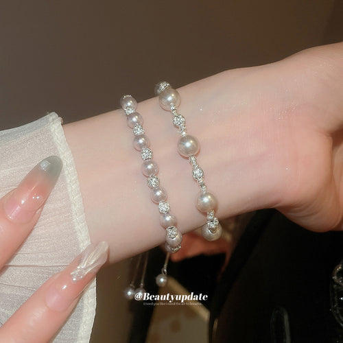 Two pink pearl rhinestone bracelets stacked on wrist