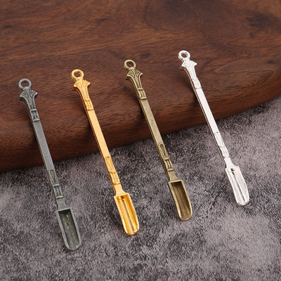 Four ornate metal mini scoop charms displayed in antique pewter, gold, antique bronze, and silver finishes.