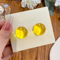 Translucent Yellow Round Resin Stud Earrings With Metal Details view 1