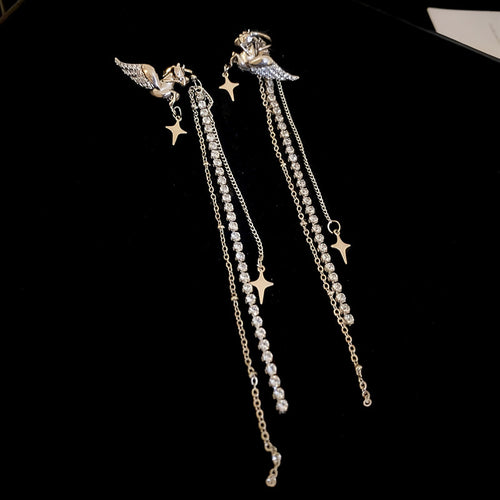 Styled wear view of 飞马星星流苏耳夹 showing winged horse tops with star charms, clear stones, and multiple chain tassels