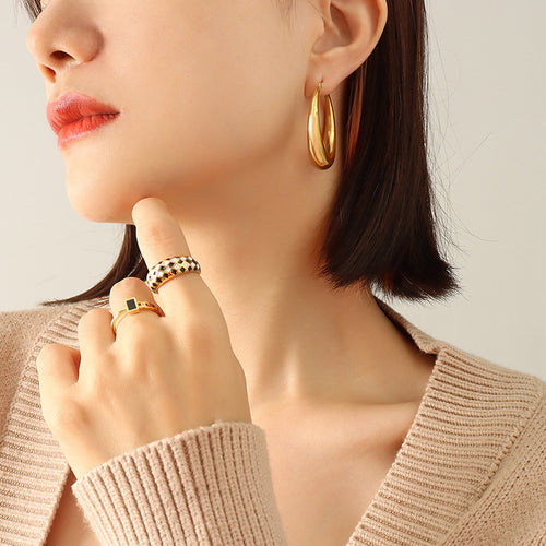 Side view of gold U-hoop on ear, beige knit top