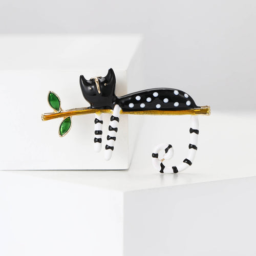 Black polka-dot cat on gold branch