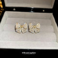 Gold Tone Crystal Bow Stud Earrings With Small Pearl Details view 2
