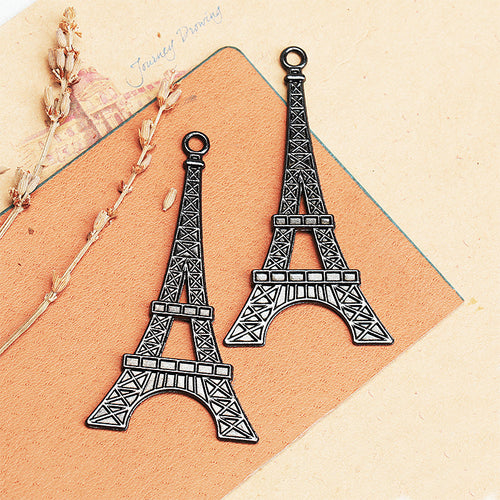 Antique bronze and antique silver Eiffel Tower pendants on a tan card