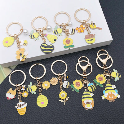 Overview showing the available color and design variations of the sunflower bee and gnome metal keychain