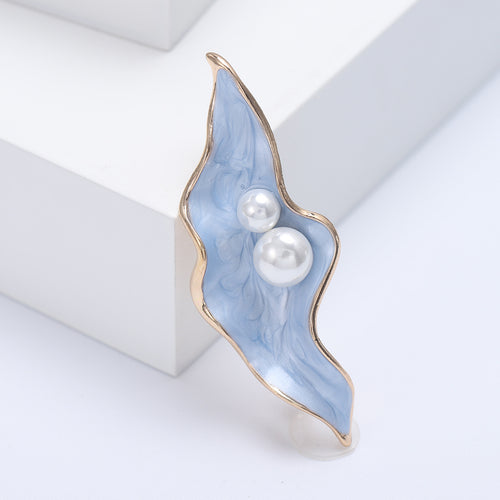 Angled display of slender curved leaf holding a cluster of three white pearl-like beads