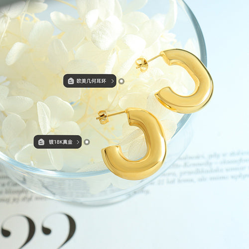 Pair gold hollow C-hoops on glass flowers material tags
