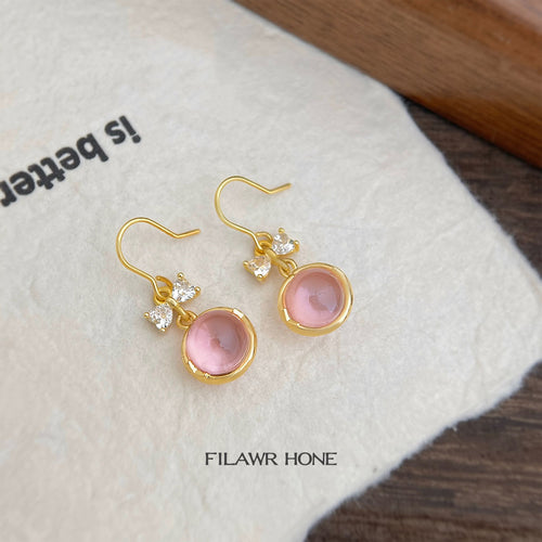 Pair of gold pink glass cabochon bow hooks on cream cloth