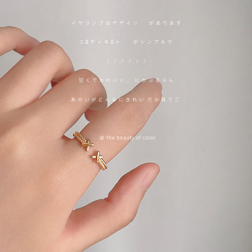 Gold X-end open ring worn on finger with Japanese text overlay