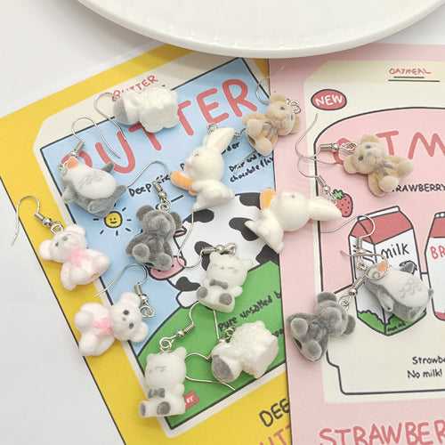 Flocked animal earring pairs scattered on butter and milk themed cards