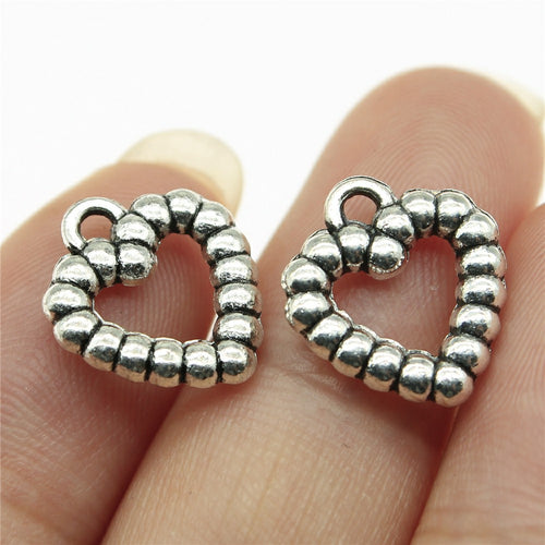 Open heart outline formed by raised bead-like segments shown close up on a hand