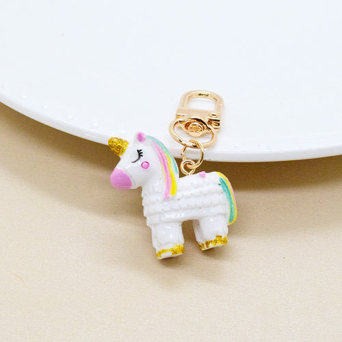 White unicorn charm pink nose gold horn standing near white plate