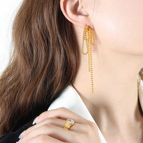 Model wearing gold ball-chain tassel bow dangle earring
