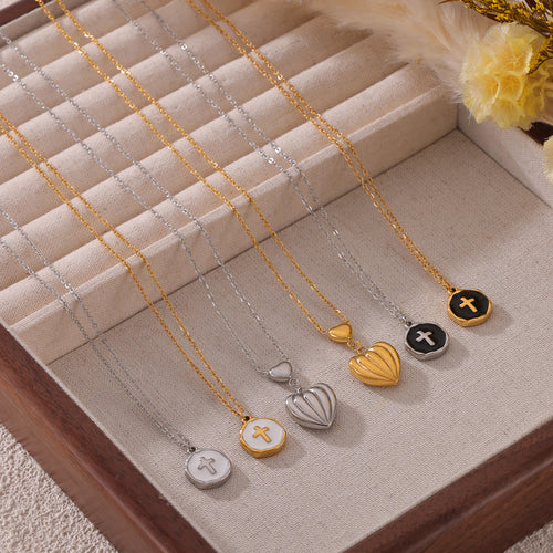 Six heart and cross coin necklaces arranged in a fabric tray