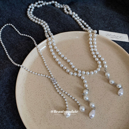 white pearl look necklaces in three beaded designs shown in an on-ear styling view