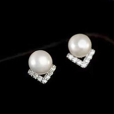 Silver tone pearl V-shape CZ studs pair on black background