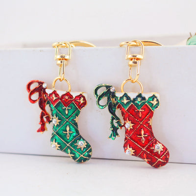 Two gold-tone stocking keychains in red and green hang side by side.