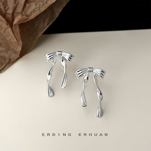 Silver ribbon streamer bow studs on cream surface