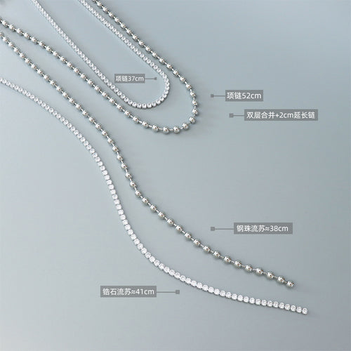 Disassembled layered chains with printed length labels on gray