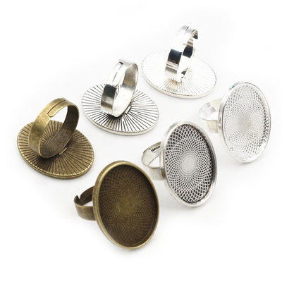 Front overview of oval mesh bezel ring settings in mixed metal tones arranged on a light background