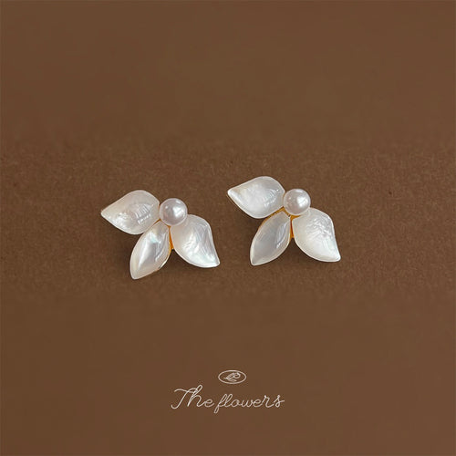 Gold-tone pearl-center white-shell-leaf studs in the first product display.