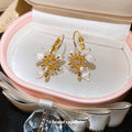 White Floral Hoop Earrings with Gold Tone Leaf Details view 4