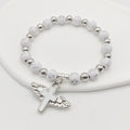 White Cross Bead Stretch Bracelet Winged Cross Charm view 1