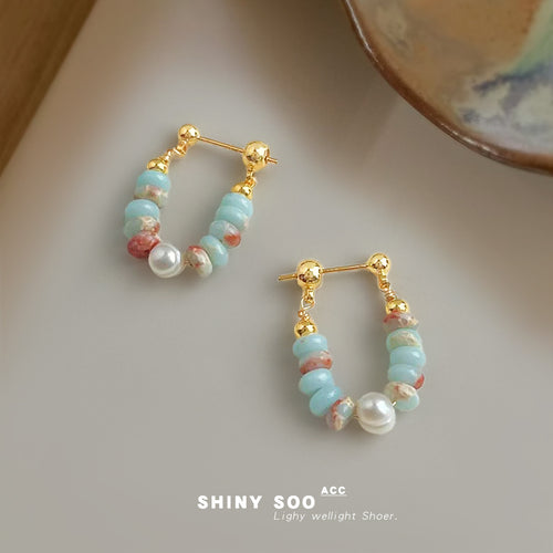 Gold-tone aqua-disc pink-white-chip hoop drops in the first product display.