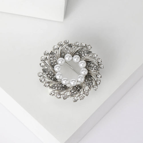 Close-up product view showing the colors and surface details of the pearl center floral wreath brooch