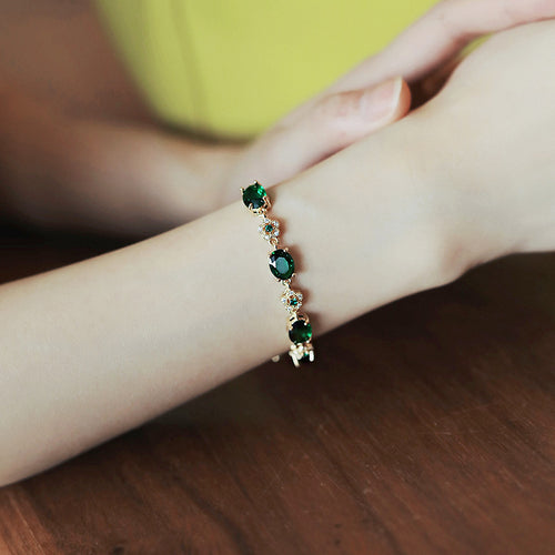 gold-tone bracelet with green oval stones and small flower links in a second styled product view