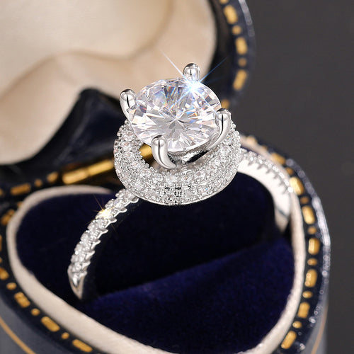 Close-up of open halo center CZ and pavé halo in blue velvet box