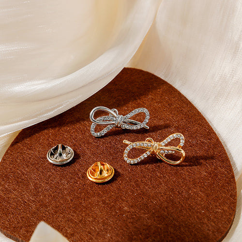Silver and gold crystal bows with matching butterfly clutches on pad