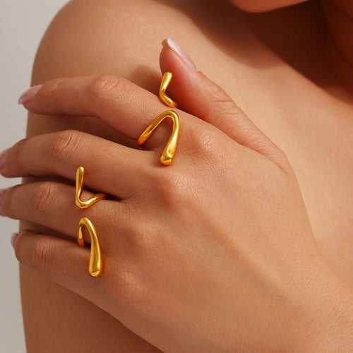 Model wearing multiple gold open wave geometric rings