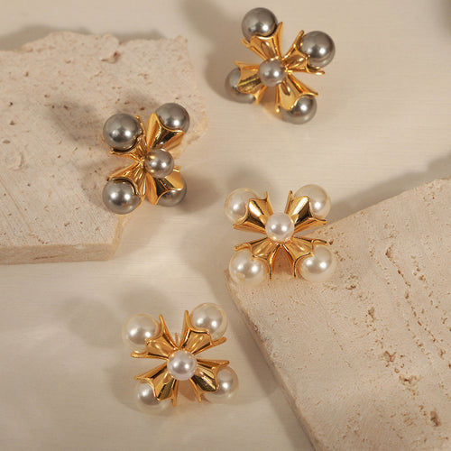 White and gray pearl cross studs on stone surface
