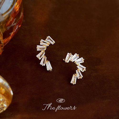 Gold baguette CZ C-curve climbers on brown velvet