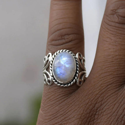 Product view showing antiqued silver-tone opalescent oval filigree ring