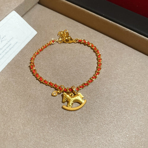 Gold red-thread chain bracelet with solid rocking horse charm