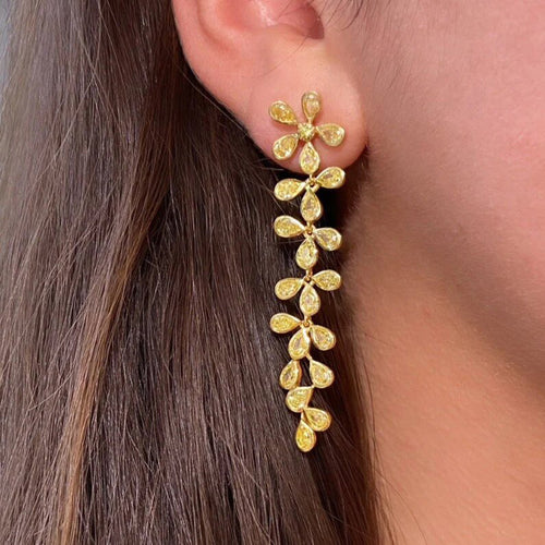 Gold Tone Leaf Branch Long Drop Earrings with Clear Stone Accents shown in styled view