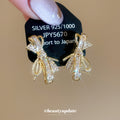 Gold Tone Crystal Bow Tassel Stud Earrings With Polished Metal Details view 1