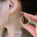 Gold Tone Twisted Medium Hoop Earrings with Detailed Finish view 1