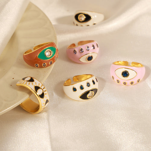 Assorted enamel evil eye open rings on cream satin fabric