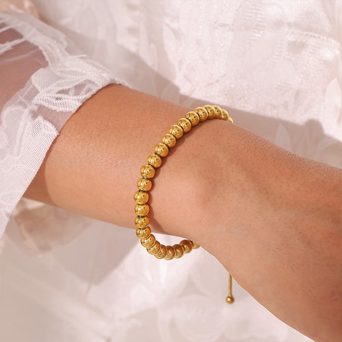 Gold bead bracelet worn on wrist side view