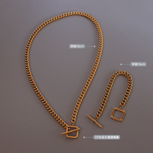 Flat lay of gold curb necklace and bracelet with length labels 50cm and 16cm