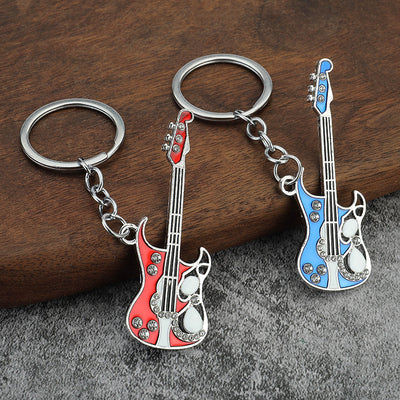 Red and blue guitar-shaped keychains displayed together on a wooden surface