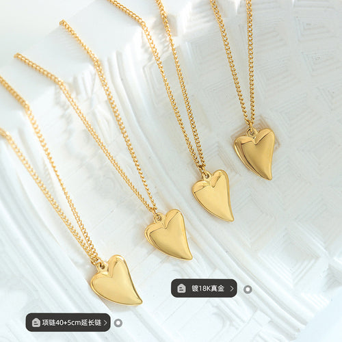 Four gold heart pendant necklaces on white tray with length plating tags