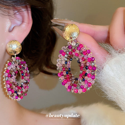 Open oval drops set with bright pink and clear crystals shown in a front product view