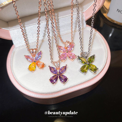 Small marquise crystal butterflies on fine rose tone chains shown in a styled front view.