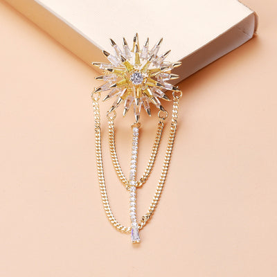 Front view of radiating crystal flower brooch with layered chain fringe against a white background.