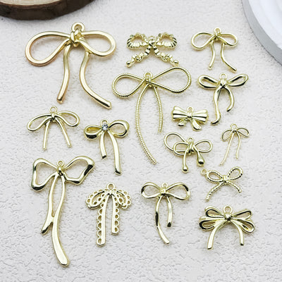 Metallic bow and butterfly charms arranged on a light background
