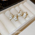White Enamel Bow Stud Earrings With Gold Tone Edges view 2
